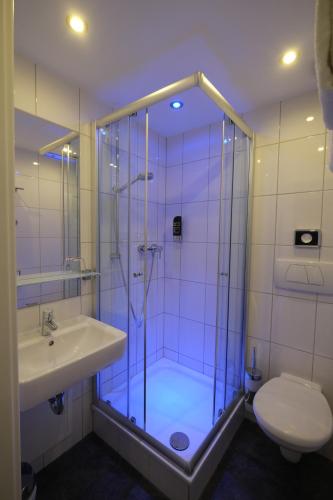 
a bathroom with a shower, toilet and sink at Hotel Hohenstaufen in Koblenz
