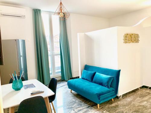 a living room with a blue chair and a table at Indipendenza Luxury Apartments in Bologna