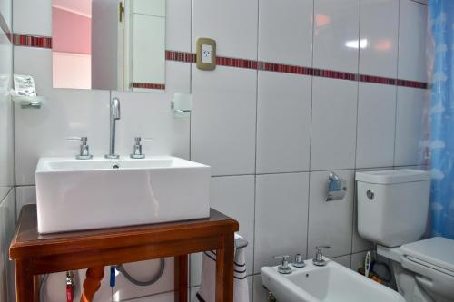 a white bathroom with a sink and a toilet at Presidencia Departamentos in Tupungato