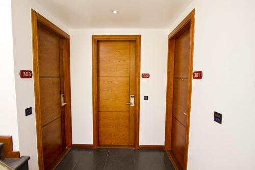 two wooden doors in a room with white walls at Dreams Grand in Hulhumale