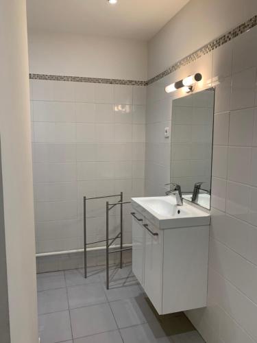 une salle de bain blanche avec un lavabo et un miroir dans l'établissement shipyard appartement, à La Ciotat