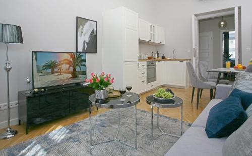 a living room with a couch and a table with flowers on it at Gem Apartment by Castle (Old Town Krakow) in Krakow