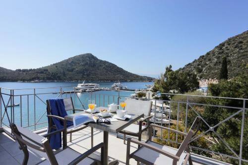 a balcony with a table and chairs and a view of the water at Hotel Aktaion in Tolo