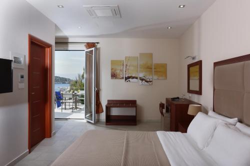 a bedroom with a bed and a view of the ocean at Hotel Aktaion in Tolo