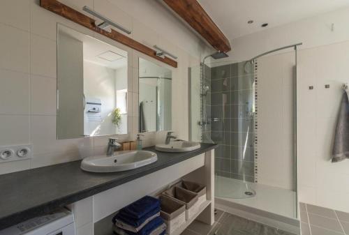 une salle de bain avec deux lavabos et une douche dans l'établissement gite de la gasignole, à Gardouch