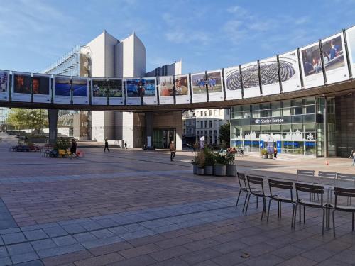 un puente sobre una plaza con sillas y un edificio en Cosy Europarlament apartment, en Bruselas