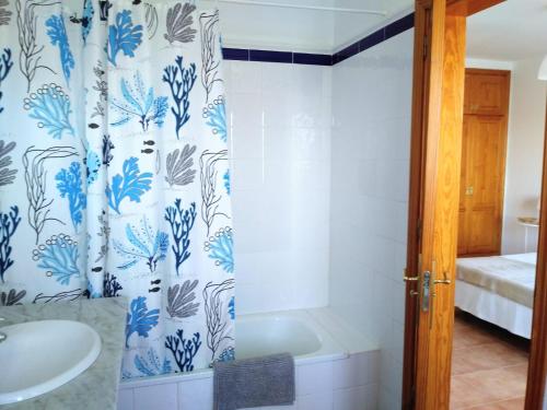 ein Bad mit einer Dusche mit einem blauen und weißen Duschvorhang in der Unterkunft Villa la 29 in Playa Blanca
