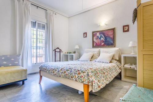 a bedroom with a bed and a painting on the wall at Casa Elizabeth in Palomares del Río