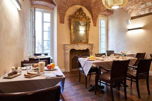 a dining room with tables and chairs and a fireplace at Locanda delle Mercanzie in Brescia