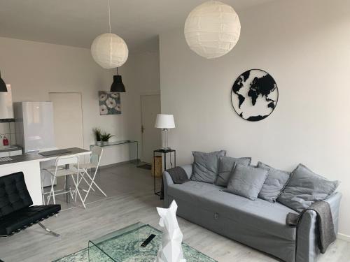 Il comprend un salon avec un canapé gris et une cuisine. dans l'établissement shipyard appartement, à La Ciotat