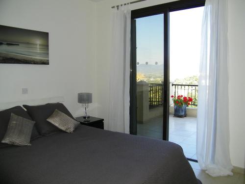 Schlafzimmer mit einem Bett und Blick auf einen Balkon in der Unterkunft Villamia in Neo Chorio