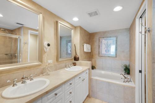 a bathroom with two sinks and a tub at Reduced Rates! Portofino Tower 1-903 Beachfront Sunset Views in Pensacola Beach