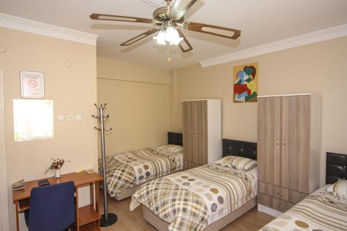 a bedroom with two beds and a ceiling fan at Sari Pension in Edirne