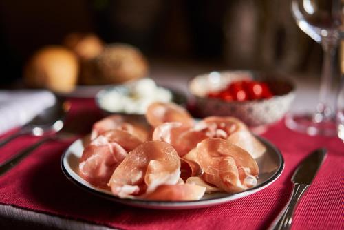 a plate of glazed donuts on a table at Locanda delle Mercanzie in Brescia