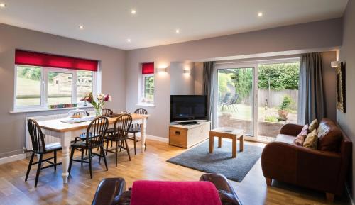 a living room with a table and a dining room at Hunters Lodge Exeter, Free Parking, Country Views, Great Wi-Fi, Large Garden in Poltimore