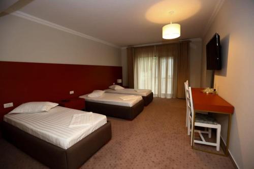 a hotel room with two beds and a desk at CASA BUDISTEANU 2 in Focşani