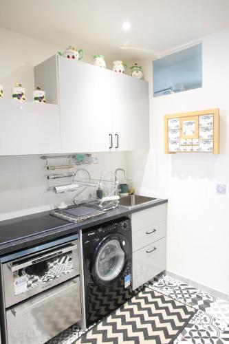 une cuisine avec un lave-linge et un sèche-linge sur un tapis dans l'établissement Montmartre's appartement, à Paris