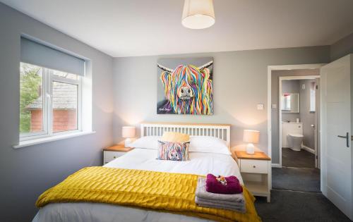 a bedroom with a bed and a painting on the wall at Hunters Lodge Exeter, Free Parking, Country Views, Great Wi-Fi, Large Garden in Poltimore