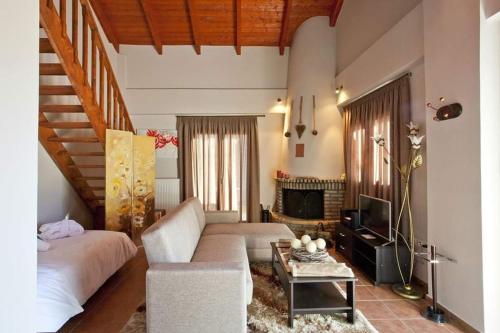 a living room with a couch and a fireplace at All Seasons Πέτρινες Παραδοσιακές Κατοικίες in Kalavrita