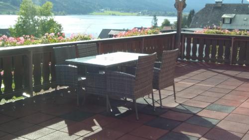 a patio with a table and chairs on a balcony at Haus Birke in Weissensee
