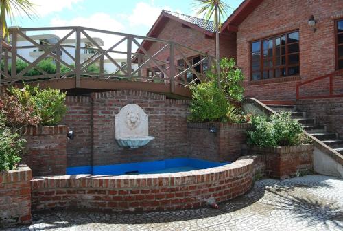 una casa de ladrillo con una fuente frente a Sol del Sur Gesell en Villa Gesell