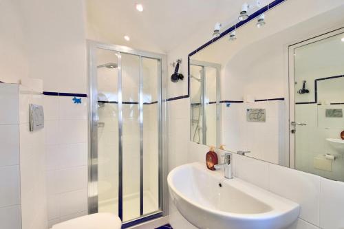 a white bathroom with a shower and a sink at Vela Portofino by KlabHouse in Portofino