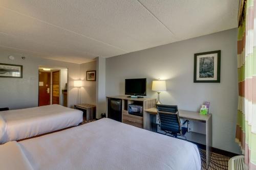 a hotel room with two beds and a desk with a television at La Quinta by Wyndham Sevierville / Kodak in Sevierville