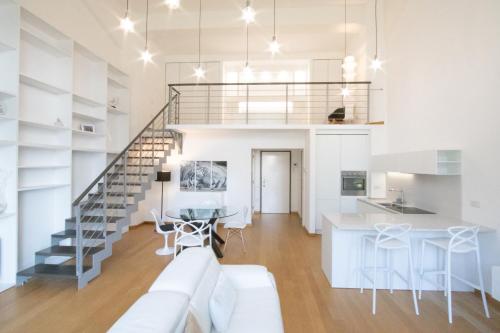 a living room with a white couch and a staircase at Loft Milano Manifatture in Milan