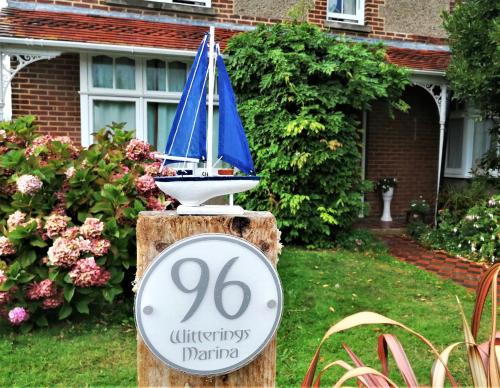 une maison dotée d'un panneau avec un voilier à bord dans l'établissement The Witterings Bed and Breakfast, à Chichester