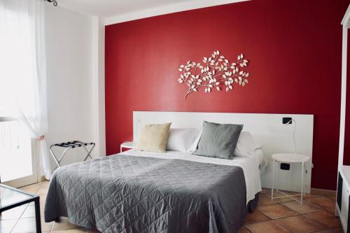 a bedroom with a bed with a red wall at Residence Il Portico in Casale Monferrato