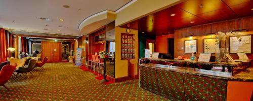 a restaurant with a counter and chairs and a bar at Trip Inn Frankfurt Nordwestzentrum in Frankfurt/Main