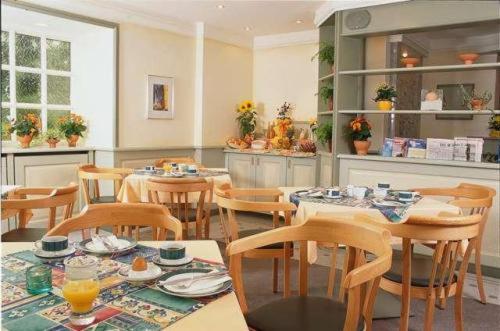 a dining room with tables and chairs in a room at Kocks Hotel Garni in Hamburg