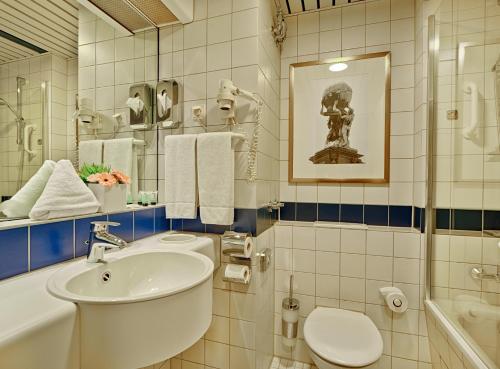 Trip Inn Frankfurt Nordwestzentrum في فرانكفورت ماين: حمام أبيض مع حوض ومرحاض