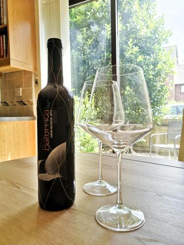 a bottle of wine and two glasses on a table at CF10 House - Cardiff City Centre in Cardiff