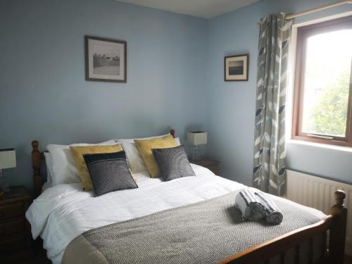 a blue bedroom with a bed with a hat on it at CF10 House - Cardiff City Centre in Cardiff