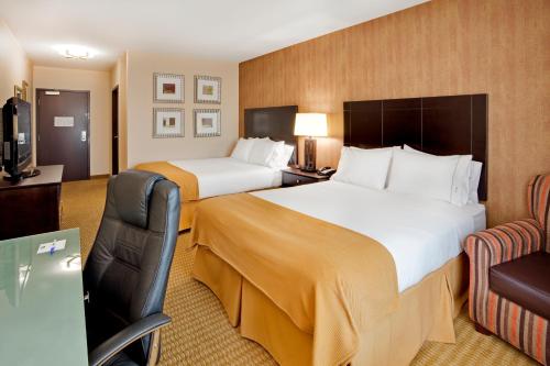 a hotel room with two beds and a chair at Holiday Inn Express Hotel & Suites Lebanon by IHG in Lebanon