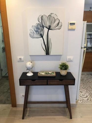 a table with a picture of flowers on the wall at La Laguna Luxe Apartment in La Laguna