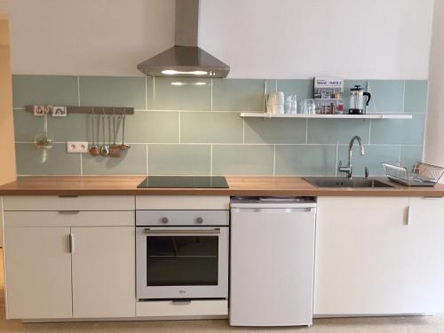 une cuisine avec des armoires blanches et un évier dans l'établissement Flat in the historical city center, à La Ciotat