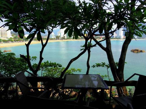 a table and chairs with a view of the ocean at Hoang Son hotel in Nha Trang