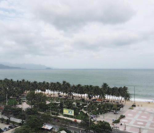 a view of a beach with palm trees and the ocean at Hoang Son hotel in Nha Trang