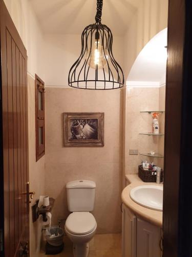 a bathroom with a toilet and a sink and a light at Dar Om Ali ElGouna Sabina y160 2 14 in El Gouna