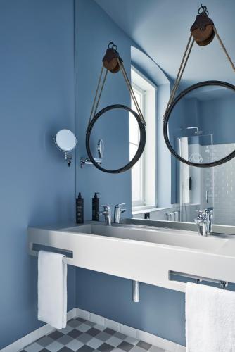 a bathroom with a sink and a mirror at The Modernist Hotel in Trieste