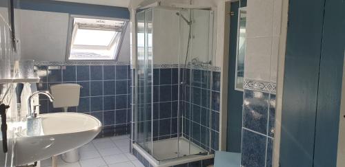een blauwe betegelde badkamer met een wastafel en een douche bij Noord-Hollands Hof Dream in Spijkerboor