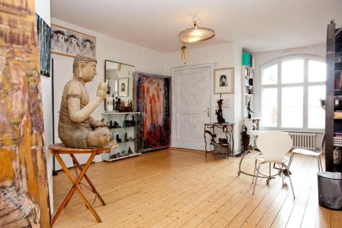 a living room with a statue on a table at Künstlerloft im Herzen von Kreuzberg in Berlin