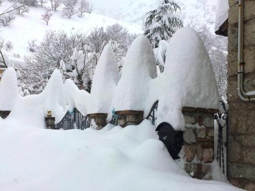a fence covered in snow next to a house at MANSARDA VITI - Sguardo su Frontone - in Frontone