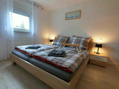 a bedroom with a bed with two lamps and a window at Moderne helle 2,5 Zimmer Wohnung mit großem Bad und Küche in Trossingen in Trossingen