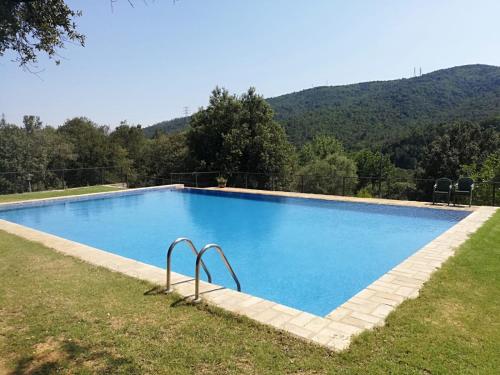 a large blue swimming pool with mountains in the background at Casa Rural Can Met in Llorá