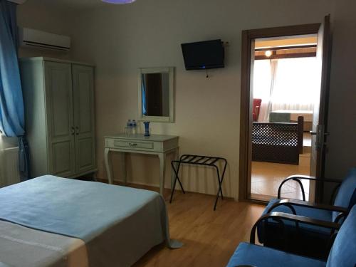 a bedroom with a bed and a desk and a television at Sapanca Dilek Konagi Hotel in Sapanca