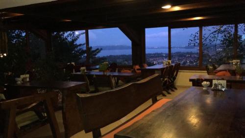 a restaurant with wooden tables and chairs and windows at Sapanca Dilek Konagi Hotel in Sapanca