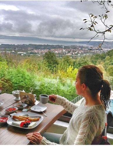 a woman sitting at a table with a plate of food at Sapanca Dilek Konagi Hotel in Sapanca